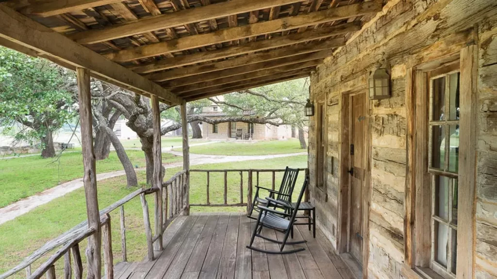 The porch of Cabin 3 at Contigo Ranch Cabin features a shaded place to enjoy rocking chairs and Hill Country scenery.